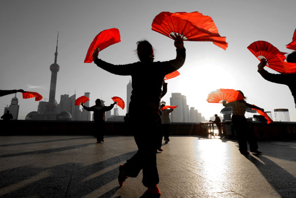 Dancer with red fan in front of Shanghai skyline