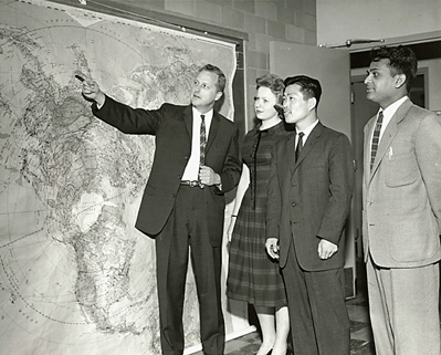Professor Borchert and students in front of a world map
