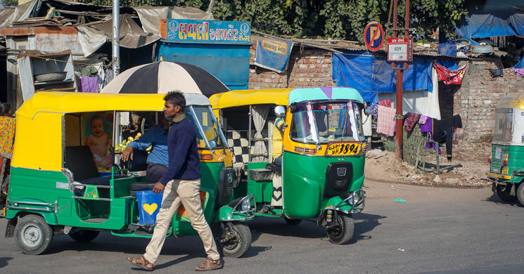 A man walking by rickshaws in India
