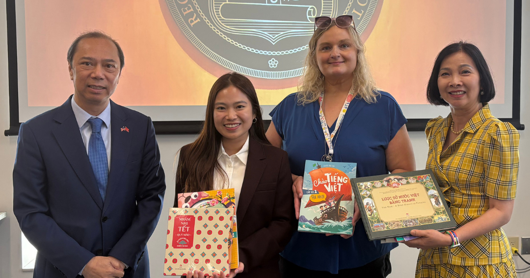 Ambassador and his wife and two staff from the Language Center hold Vietnamese children's books