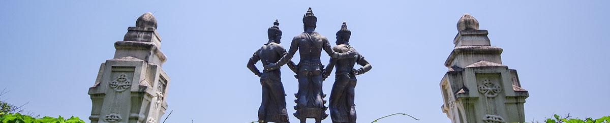 three statues standing near Thai temples