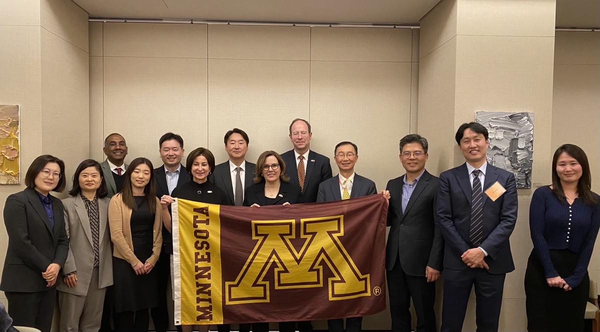 Law School alumni pose with M flag