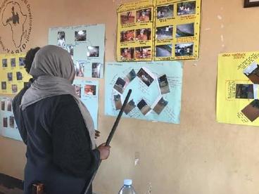 A woman in a headscarf explains the photos she chose for a collage