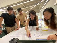 Students looking at plans for a hawker center